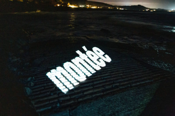 An image of a slipway with the Jèrriais word for slipway in large letters, projected onto the slipway.