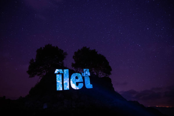 An image of an islet with the Jèrriais word for islet in large letters, projected onto L